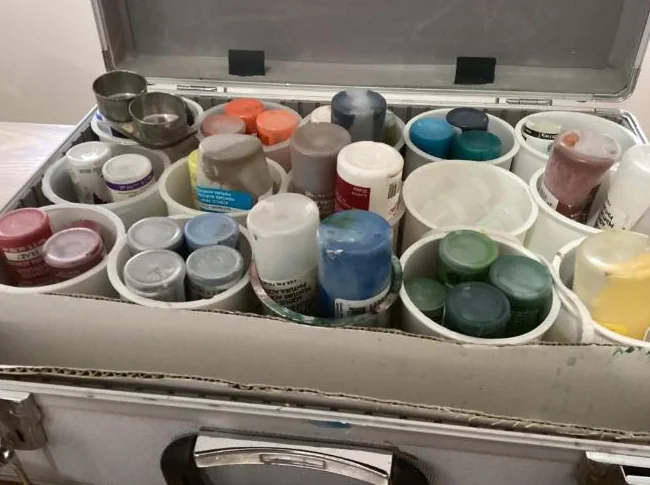 Valise pleine de tubes de peinture acrylique