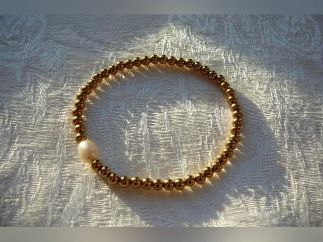 Bracelet doré , acier inoxydable et Perle d'eau douce ( femme )