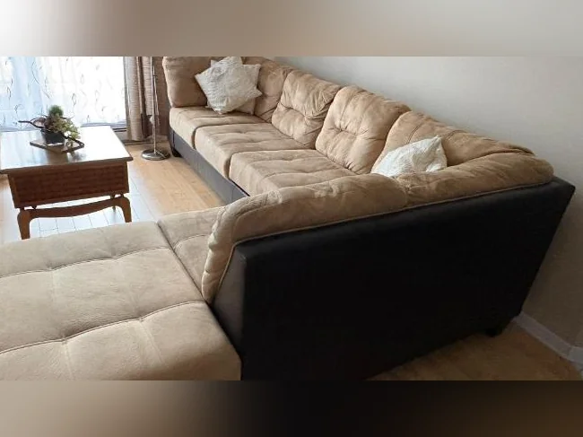 Divan en angle tissu velouté beige.