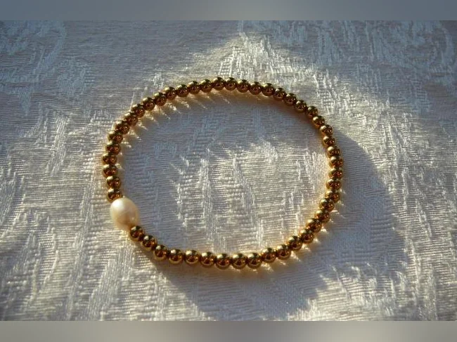 RABAIS -Bracelet , acier inoxydable, Billes dorées et Perle d'eau douce ( femme )