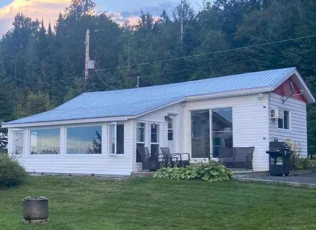 Petit chalet au bord d'un lac naturel tranquille ensemencé de truites